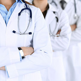 Group of modern doctors standing as a team with arms crossed in hospital office. Physicians ready to examine and help patients. Medical help, insurance in health care, best desease treatment and medicine concept.